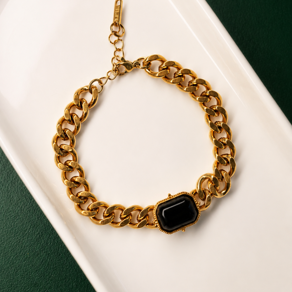 A bold gold-tone stainless steel chain bracelet with a polished black centre detail. A distinctive statement piece from the Neréa Anthi Curated Collection.