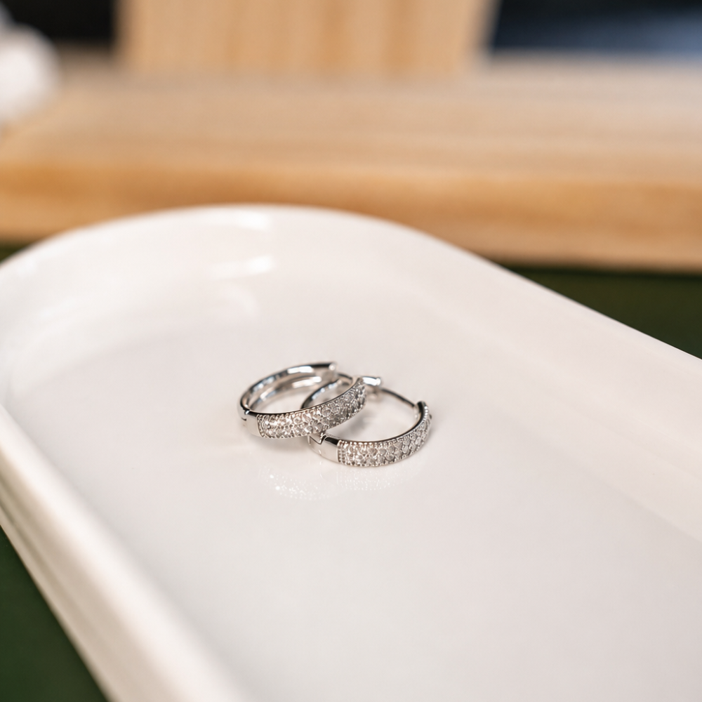 Elegant silver-tone hoop earrings with clear zircon details and stainless steel posts. A sparkling everyday pair from the Neréa Anthi Curated Collection.