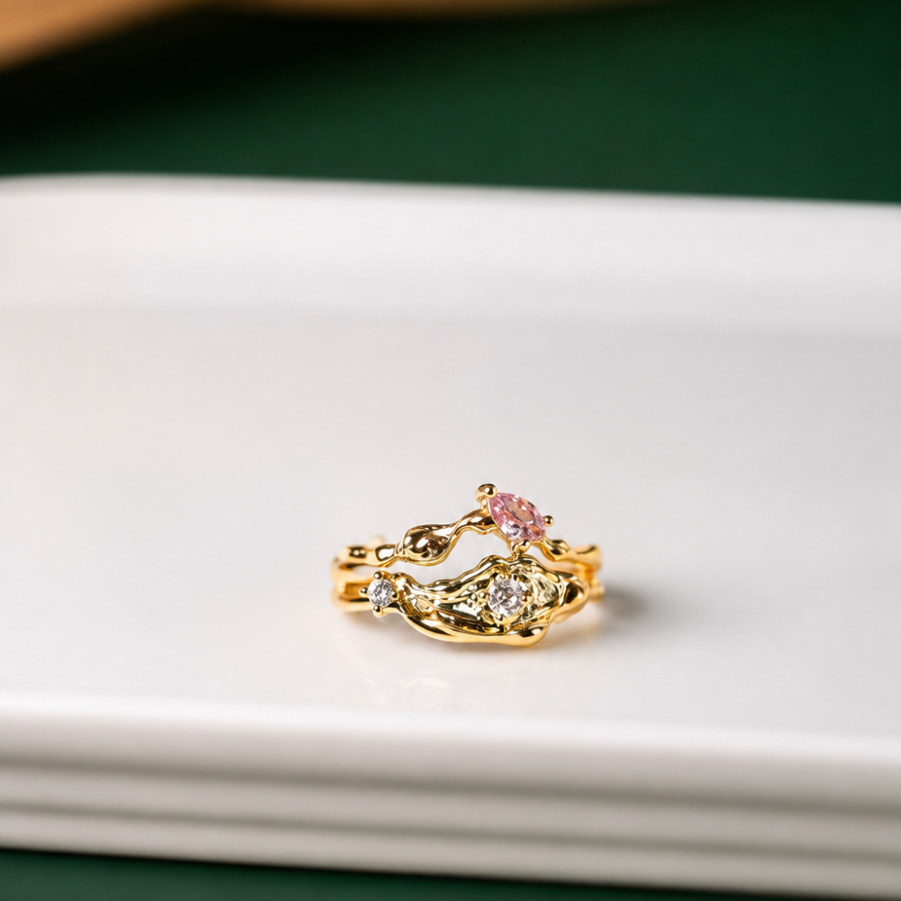 An adjustable gold ring with flowing vine details, a blush pink zircon, and clear sparkling accents. Part of the Neréa Anthi Curated Collection.