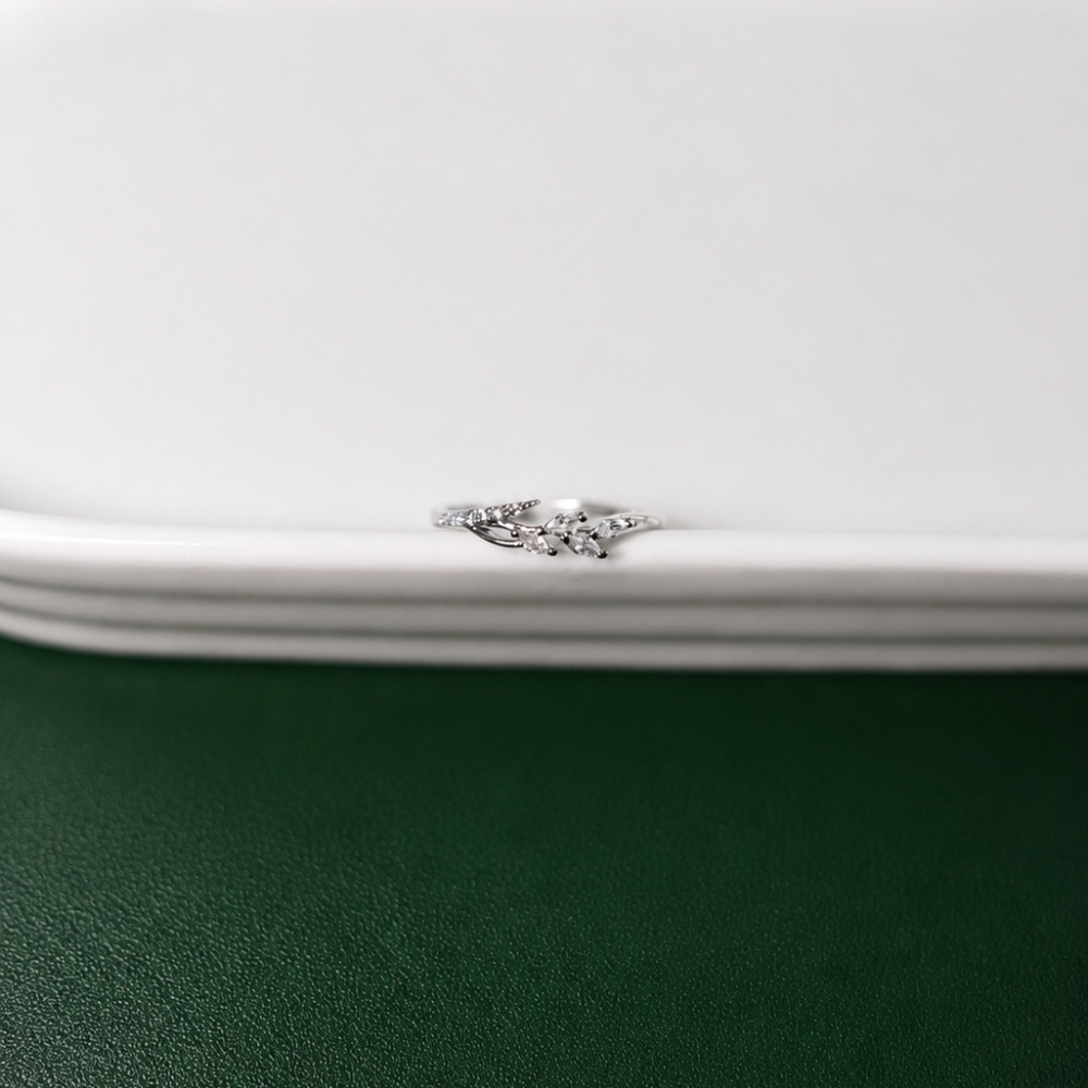 A delicate adjustable silver-tone ring with flowing leaf details and clear zircon accents. Part of the Neréa Anthi Curated Collection.