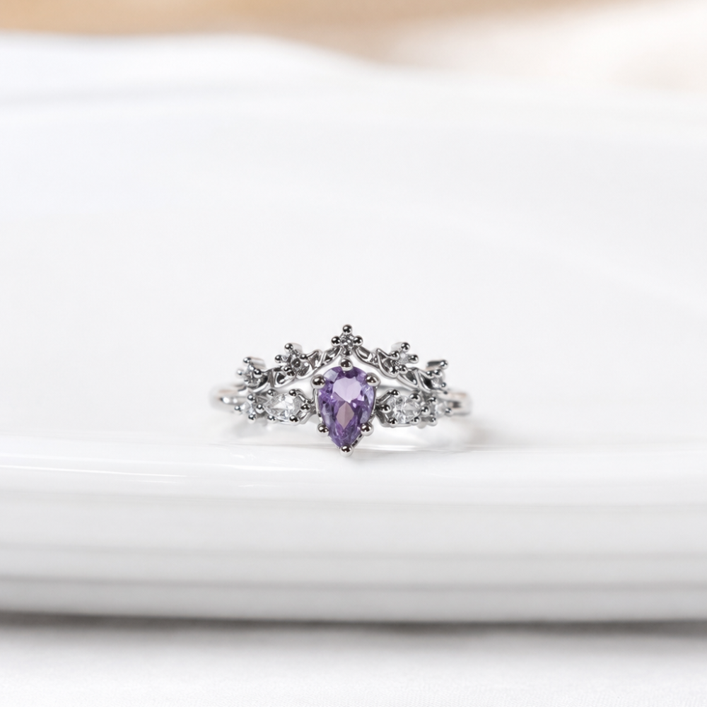 A delicate silver-tone adjustable ring with a lavender zircon centre stone and sparkling clear zircon details. Part of the Neréa Anthi Curated Collection.